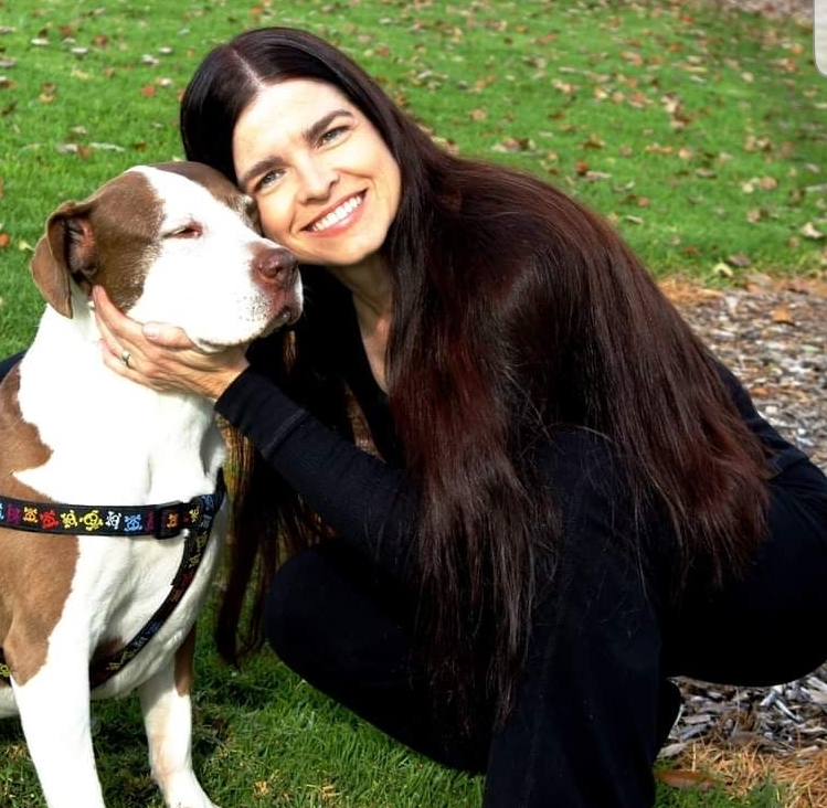 Pam Holt with her dog long haired woman hugging pitbull