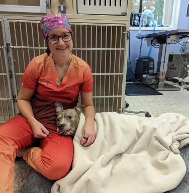 Luna with Dr. Jackie dog wrapped in blanket with vet