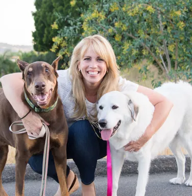 Dr. Mary with her two dogs blonde woman between two large dogs