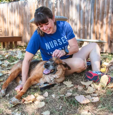 Angelo and his foster mom playing in the grass dog and woman playing in the grass