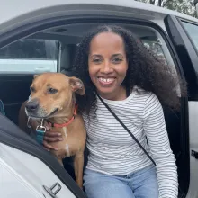 woman and dog in car with open door