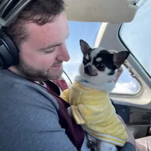 Nell and pilot in the cockpit small white dog and man in airplane cockpit