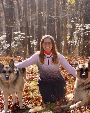 woman with 2 german shepherds in woods